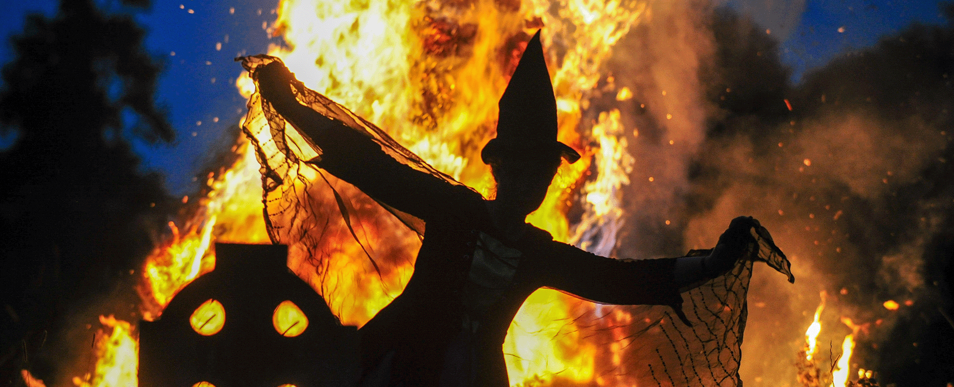 silhouette of a witch dancing in fron of the flames of a fire at the spirits of meath halloween festival